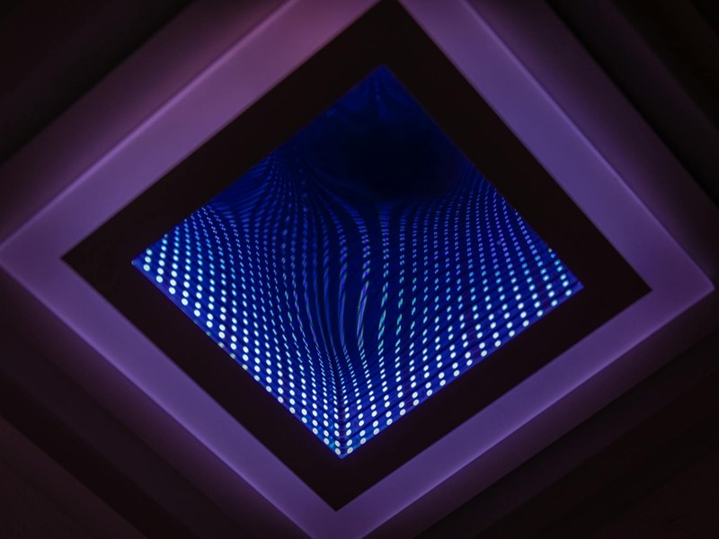 A captivating abstract view of a LED infinity mirror with vibrant light patterns.